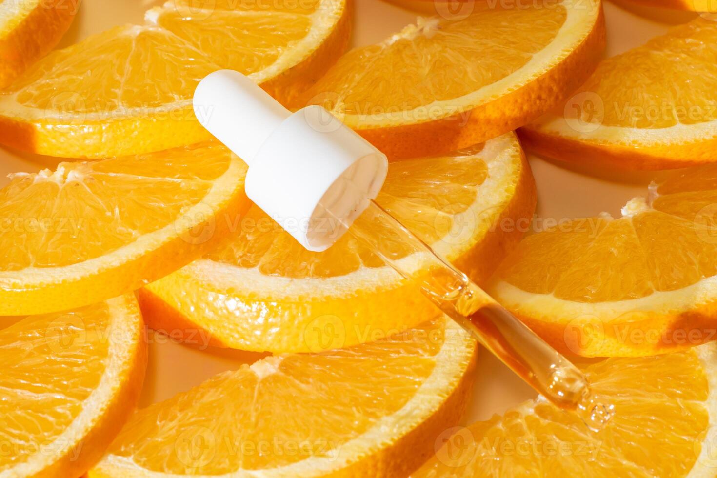 vitamin c serum i en pipett med vit keps på en bakgrund av orange citrus- frukter. citrus- grundläggande olja, aromaterapi kosmetika. organisk spa kosmetika med ört- Ingredienser foto