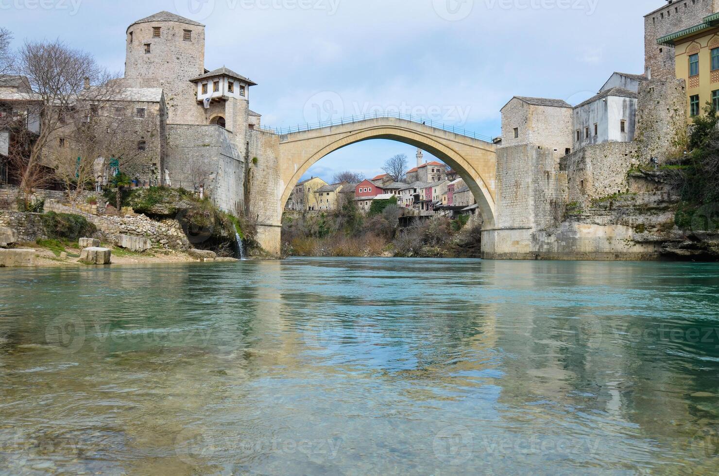 se av de gammal bro i mostar stad i bosnien och herzegovina under en solig dag. neretva flod. unesco värld arv webbplats. människor gående över de bro. foto