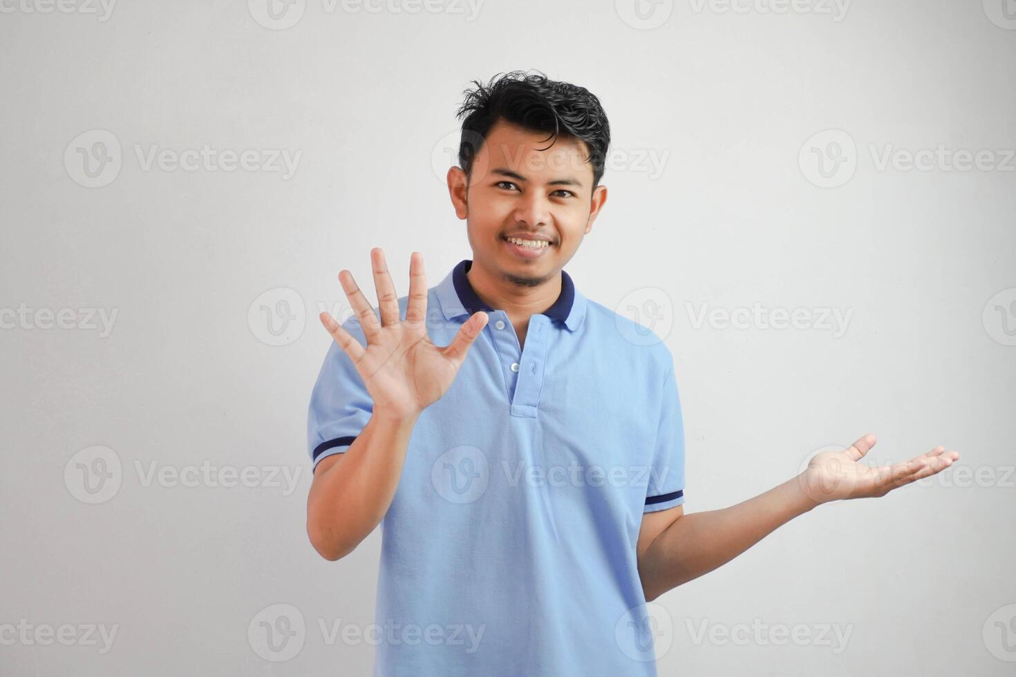 attraktiv asiatisk man med hand gest utgör avslag eller förbud medan pekande till kopia Plats förbi hans sida bär blå t skjorta isolerat på vit bakgrund foto