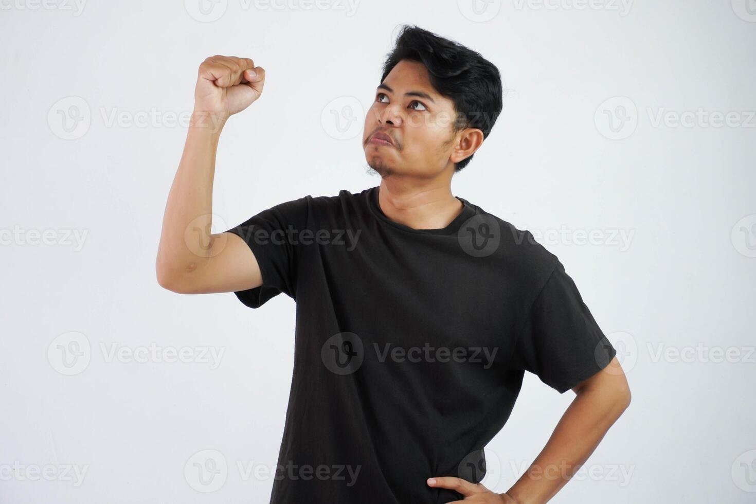 asiatisk man visa näve upp känner positiv eller Lycklig med framgångsrik bär svart t skjorta, man nöjd Lycklig handla om seger isolerat på vit bakgrund foto