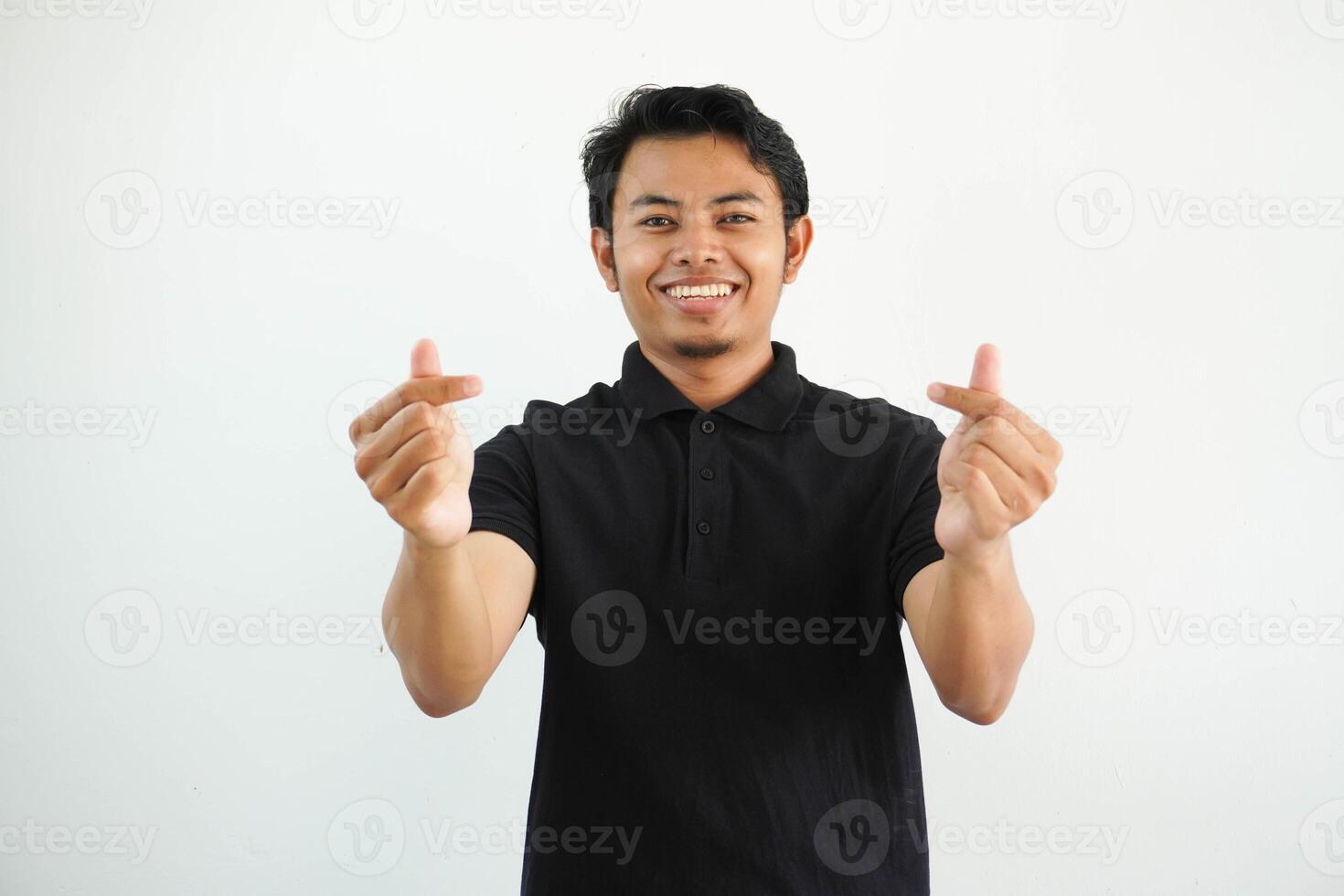 leende eller Lycklig asiatisk man som visar gest hjärta form händer eller korsning hans index finger och tumme de symbol saranghae, sarangheo, saranghaeo bär svart polo t skjorta isolerat foto