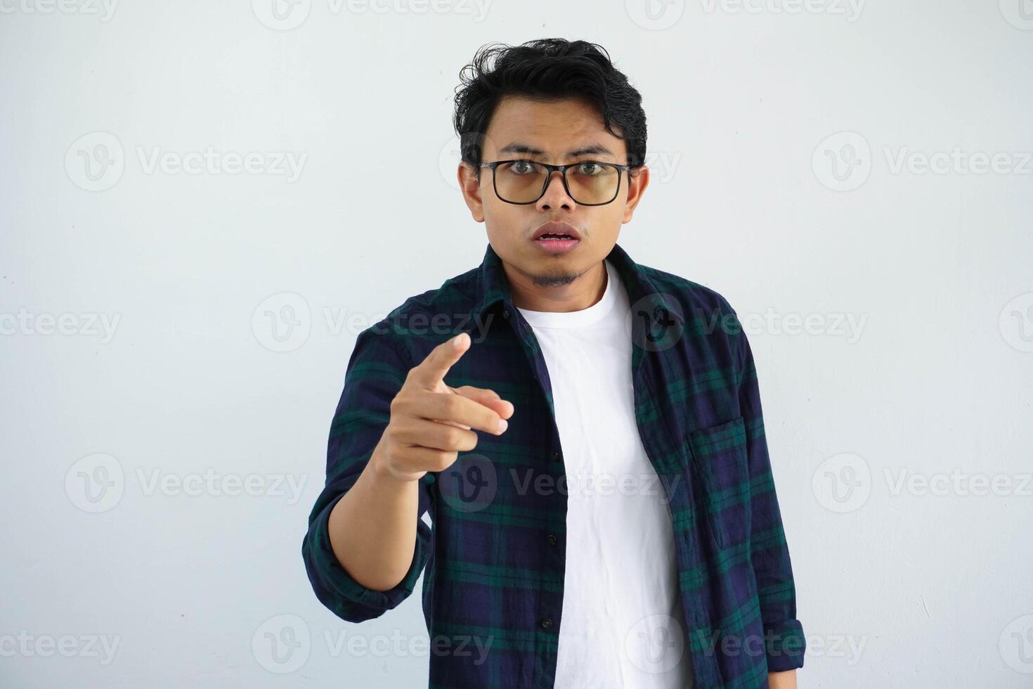 ung asiatisk man som visar förvirrad ansikte uttryck med pekande framåt- isolerat på vit bakgrund foto