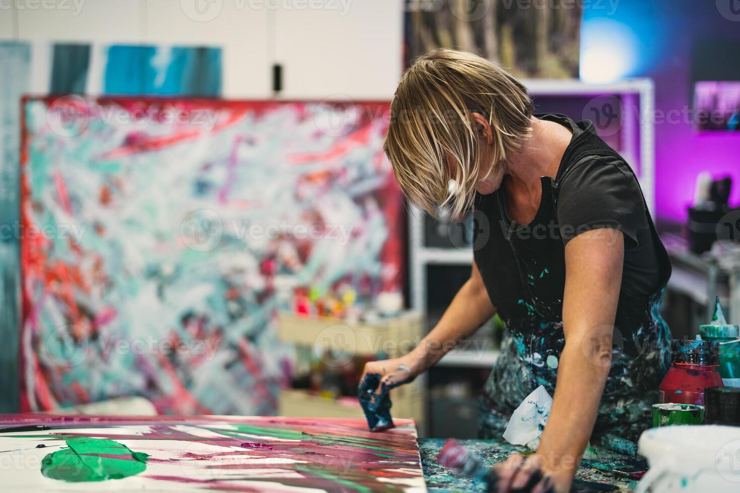 kvinna konstnär målning på duk i verkstad studio - målare arbete och kreativ hantverk begrepp foto