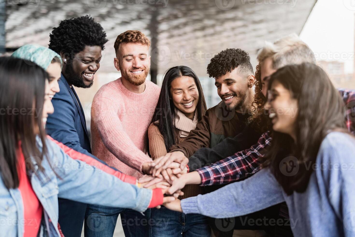 ung raser vänner stapling händer tillsammans utomhus- - vänskap och mångfald begrepp foto