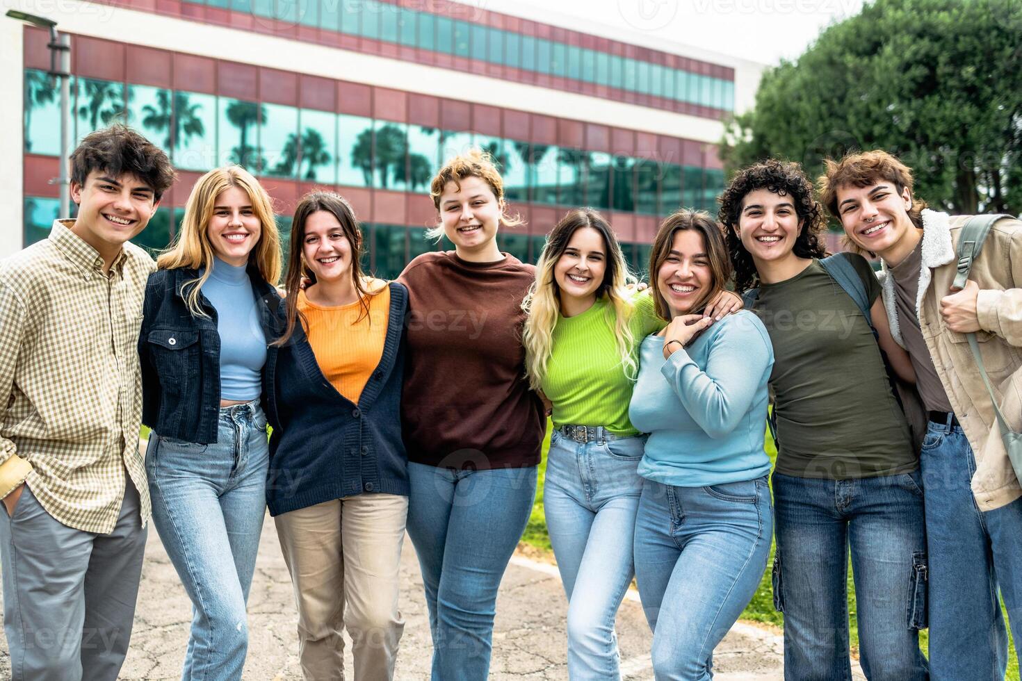 Lycklig grupp av tonåringar har roligt utanför universitet - ung studenter människor livsstil begrepp foto