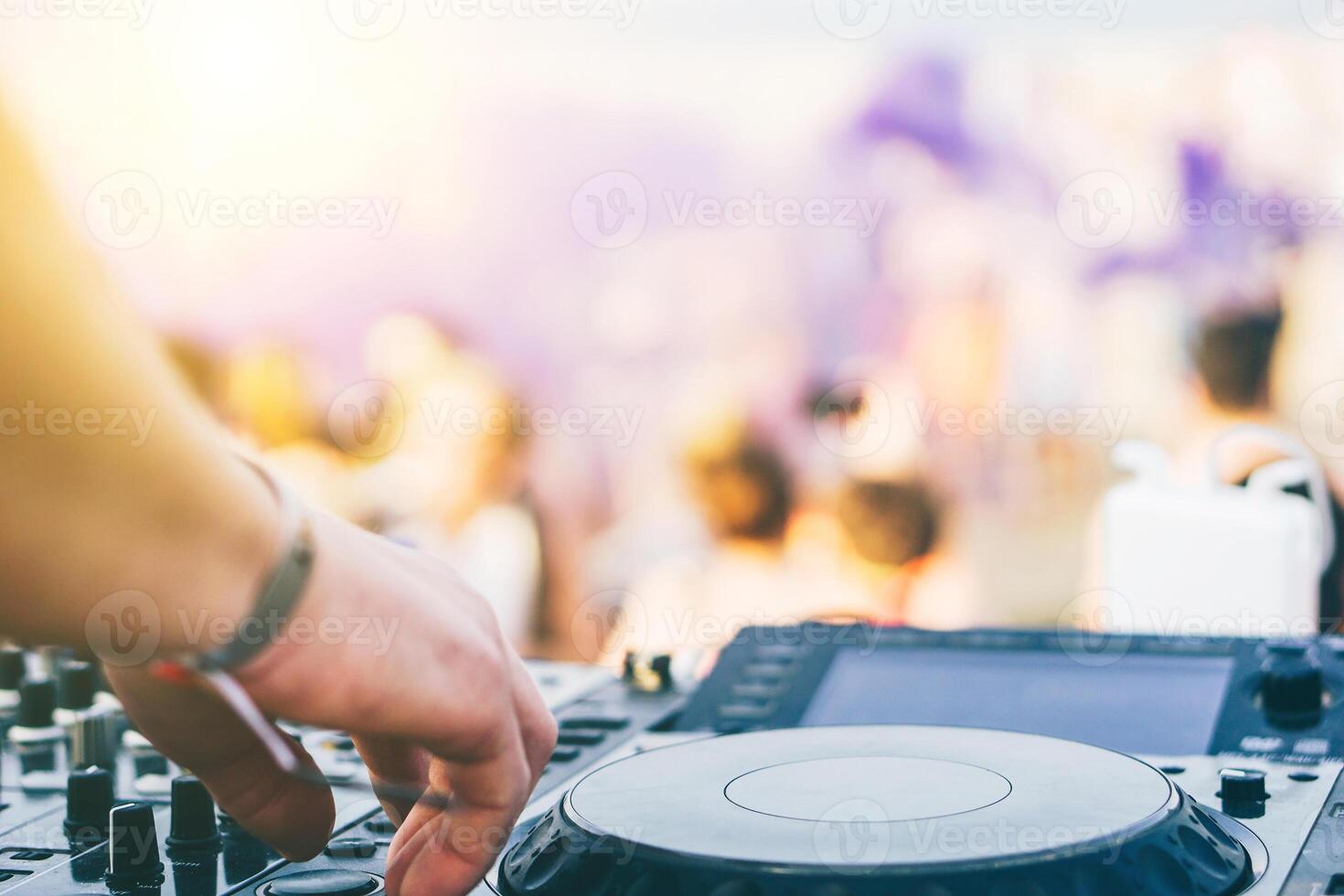 stänga upp av dj's hand spelar musik på skivspelare på en strand fest festival - porträtt av dj mixer audio i en strand klubb ovan de folkmassan dacing och har roligt - fest, sommar, musik och människor begrepp foto