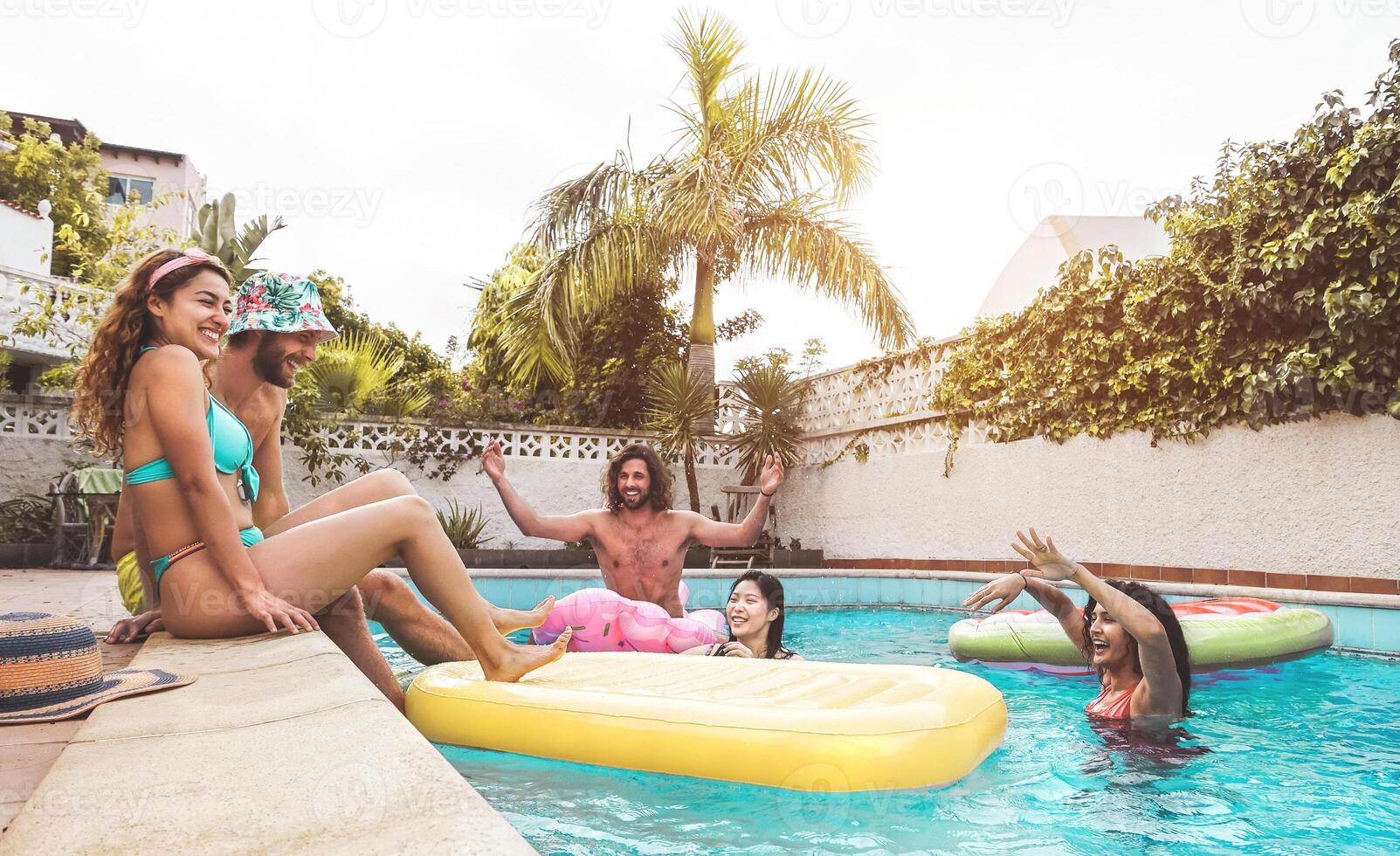 grupp Lycklig vänner njuter sommar dag i simning slå samman med uppblåsbar - ung raser människor har roligt i exklusiv tillflykt hotell - ungdom semester livsstil begrepp foto