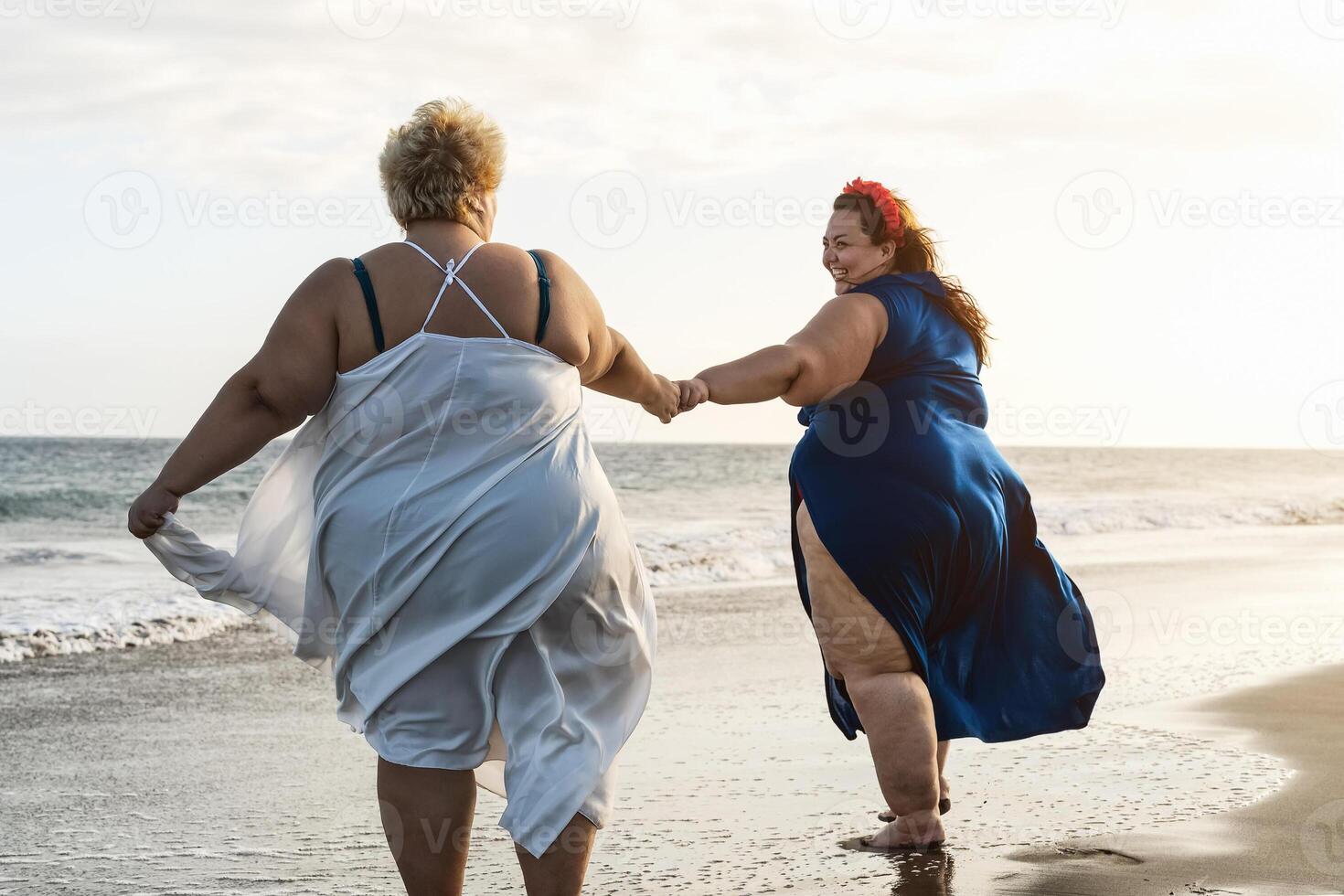 Lycklig plus storlek kvinnor har roligt på de strand under semester i tropisk destination - över storlek självsäker människor livsstil begrepp foto