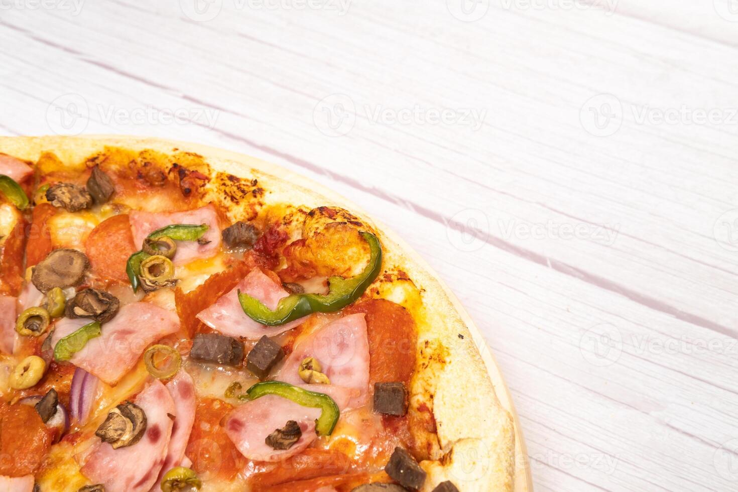 utsökt stor pizza med kalvkött och svamp på en ljus trä- bakgrund foto
