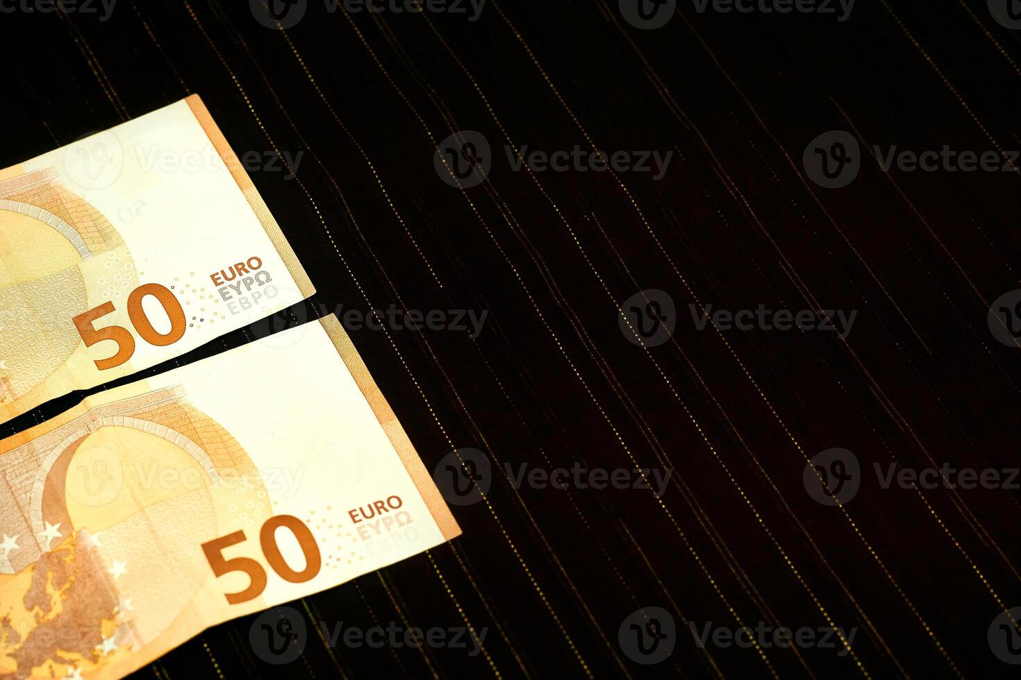 pengar. två 50 euro sedlar på mörk tyg med lurex foto