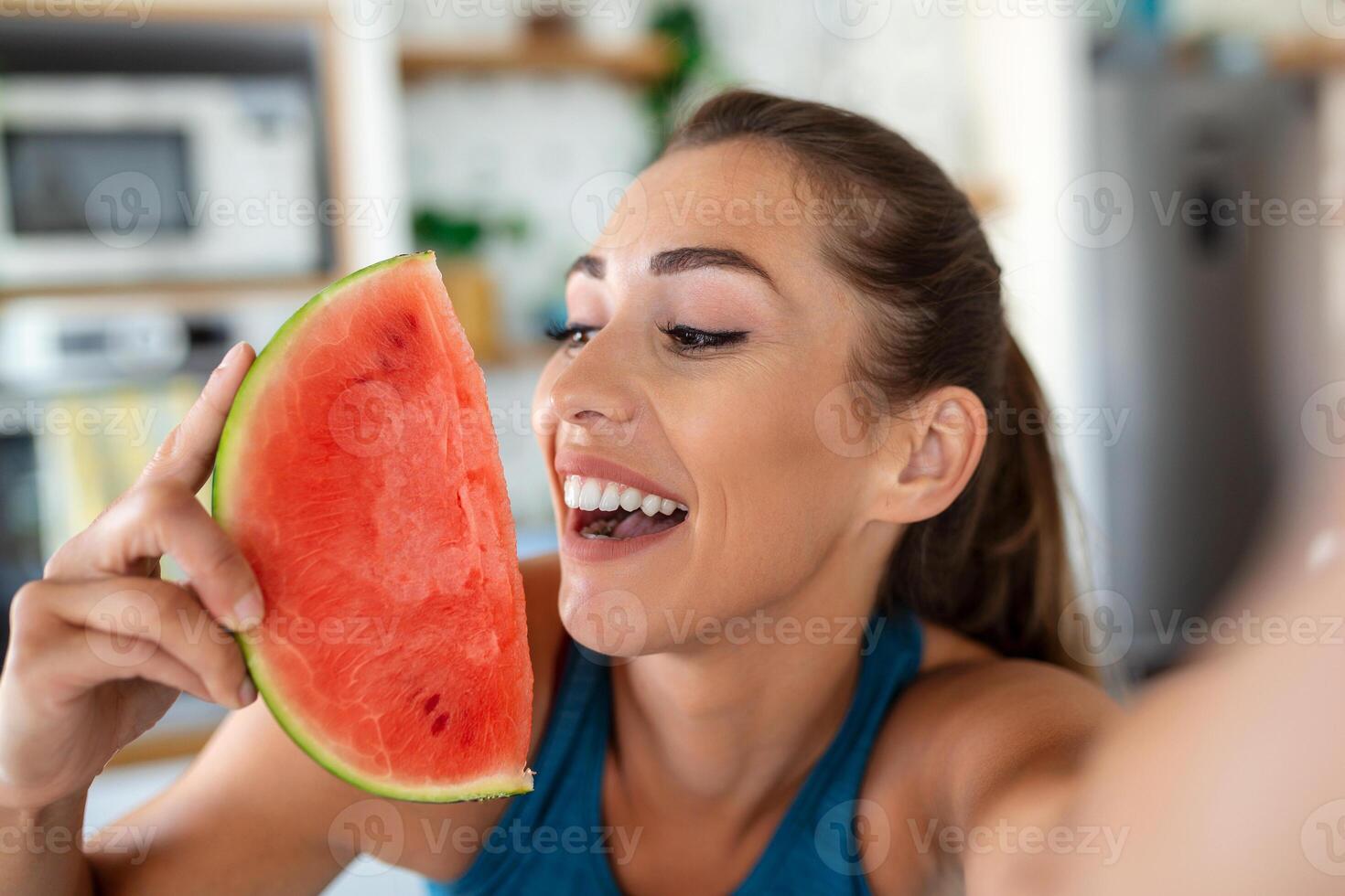 ung kvinna äter en skiva av vattenmelon i de kök. porträtt av ung kvinna njuter en vattenmelon. foto