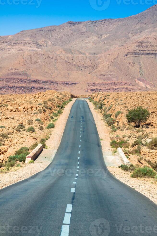 ändlös väg i sahara öken- med blå himmel, marocko afrika foto