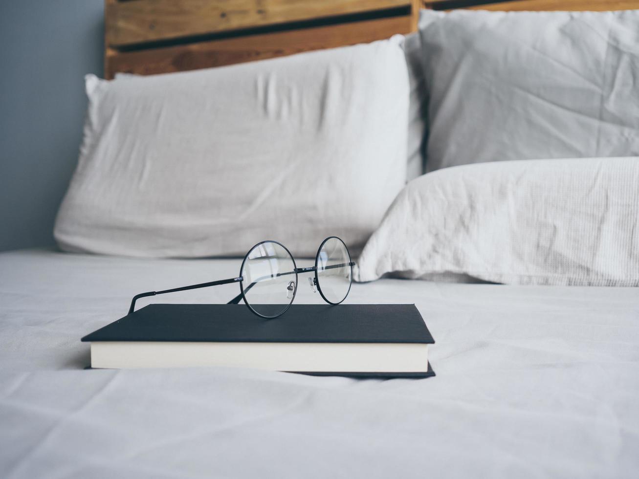 glasögon och bok i sovrummet för att läsa och koppla av. foto