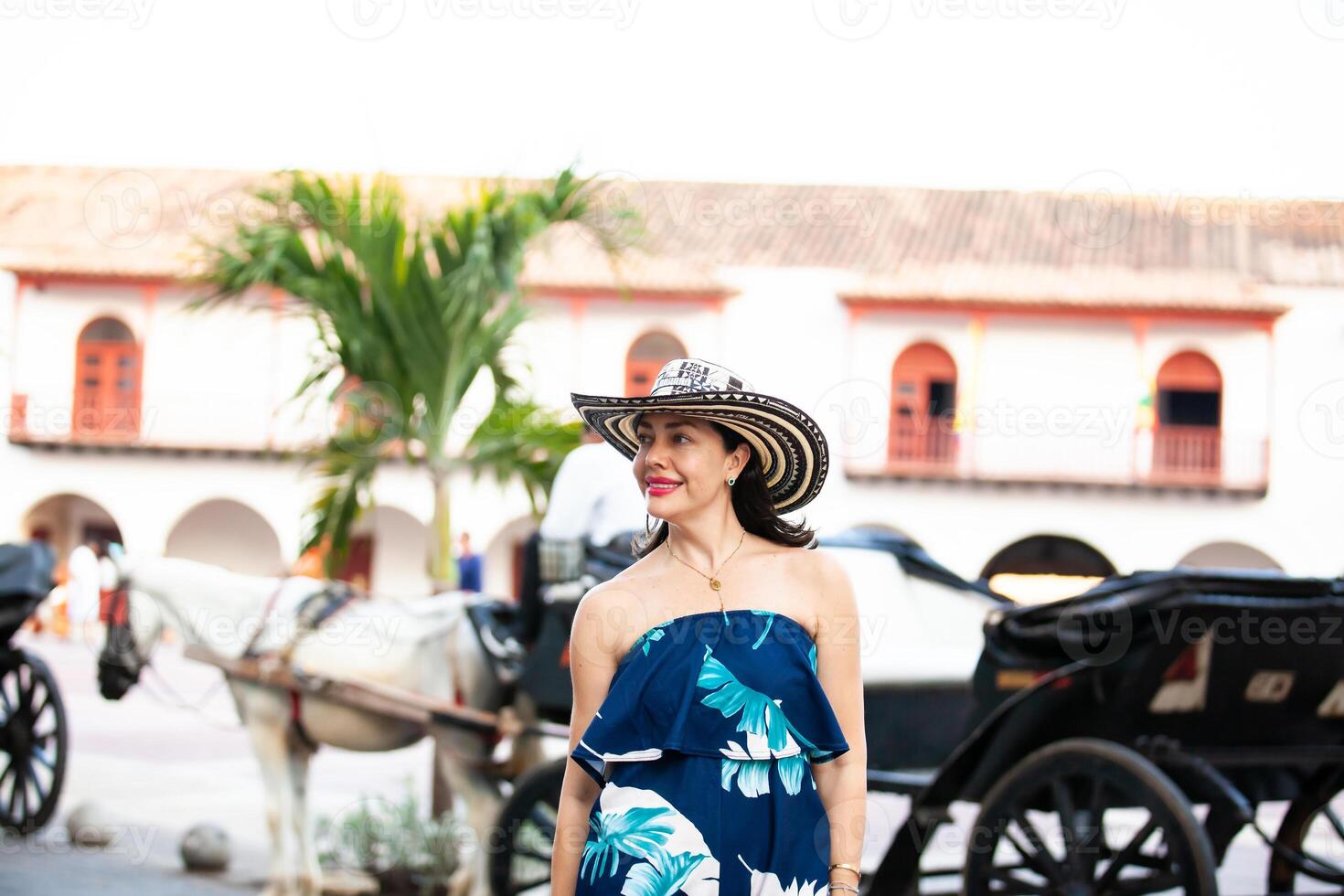 skön kvinna bär de traditionell colombianska hatt kallad sombrero vueltiao på de tull fyrkant på de historisk gator av de cartagena de Indien walled stad foto