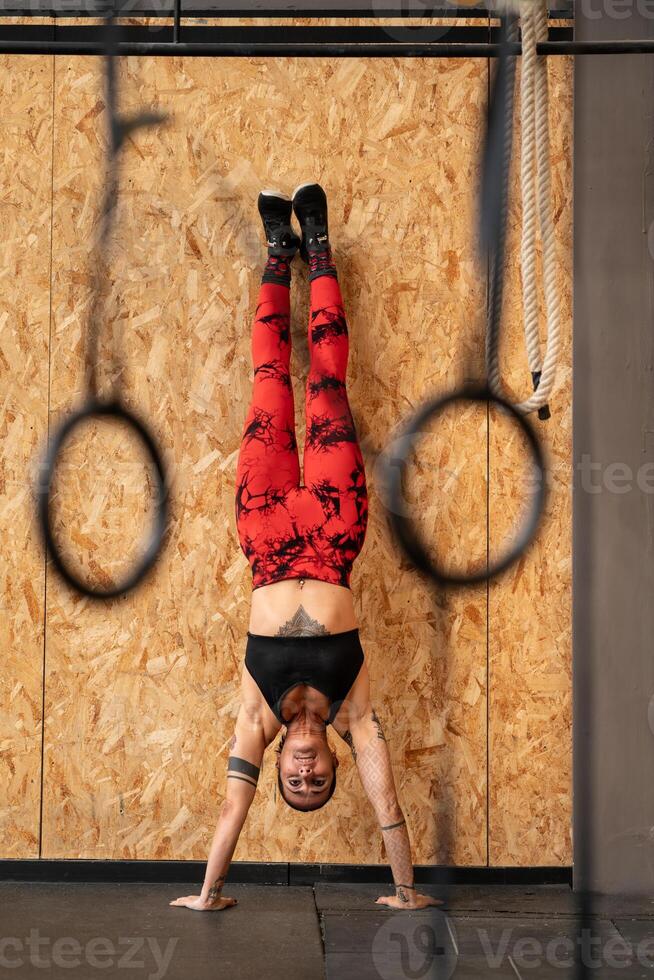 kvinna utför stå på händer övning i de Gym foto