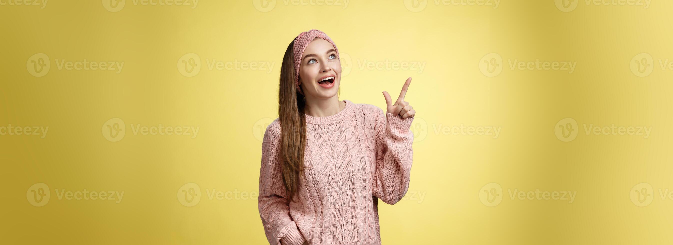 roade och imponerad drömmande Söt ung europeisk kvinna i stickat Tröja gasning underhöll dropp käke leende glada, glad, pekande, ser på övre vänster hörn upphetsad av grymt bra promo foto