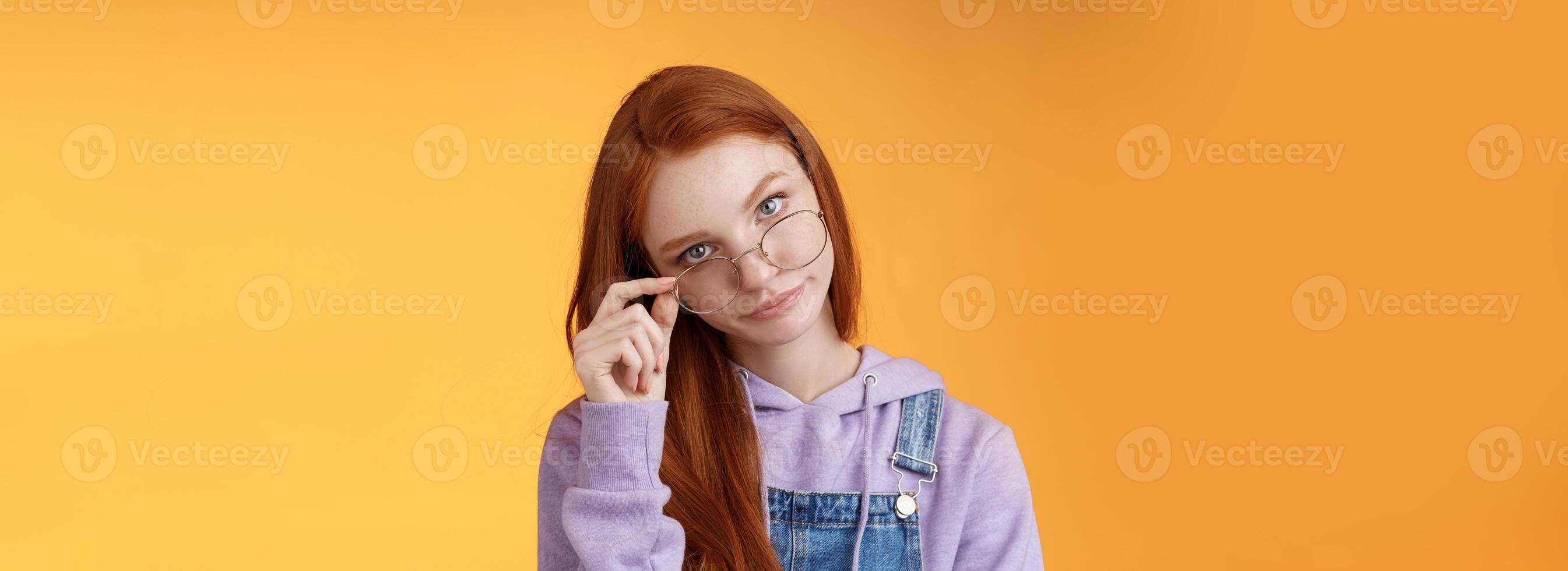 du måste vara skojar mig. irriterad rödhårig smart irriterad äldre syster se från under panna ta av glasögon rulla ögonlock flirande störd förbannad dum skämt, stående orange bakgrund foto