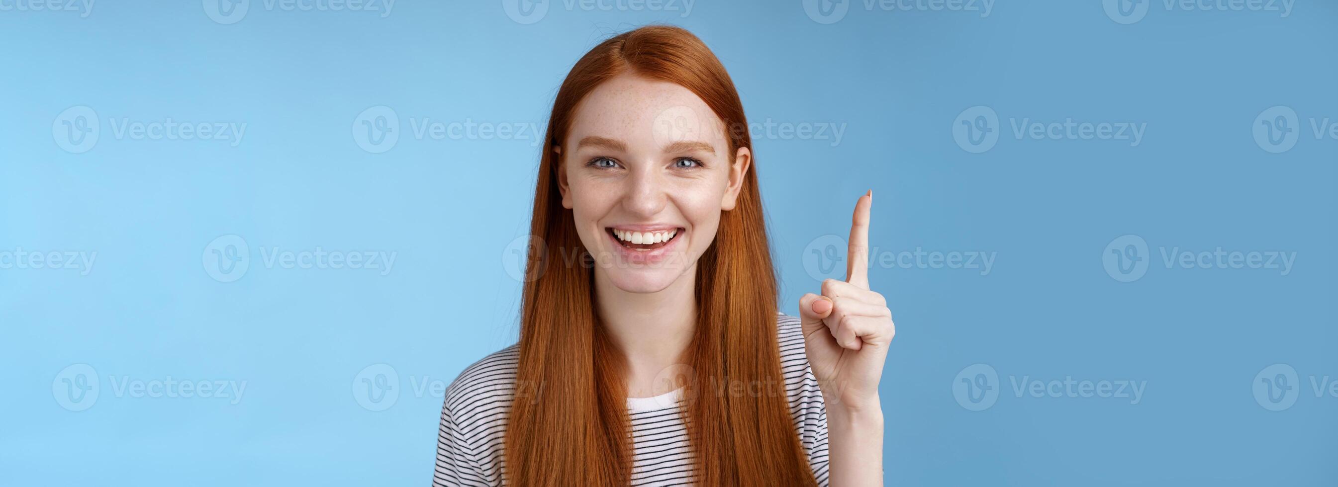 fick excellent aning plocka för du. attraktiv Lycklig vänligt utseende hjälpsam rödhårig kvinna affär assistent som visar underbar klänning kund pekande upp index finger leende glad hjälp, blå bakgrund foto