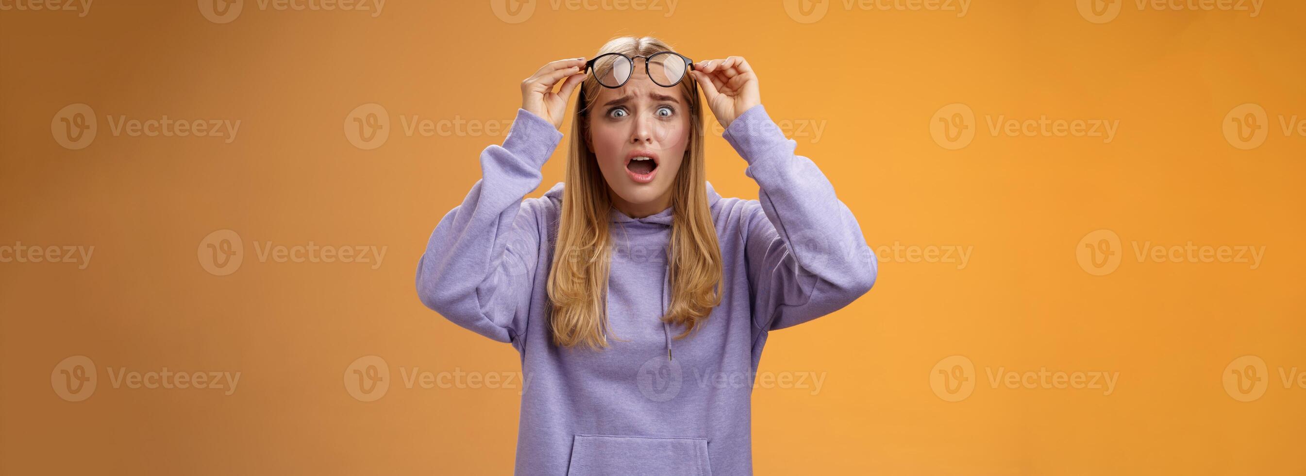 chockade bekymrad ung kvinna ser studerande ruin arbete stirrande störd upprörd ta av glasögon popping ögon kamera gasning mållös fruktansvärd olycka hände, orange bakgrund foto