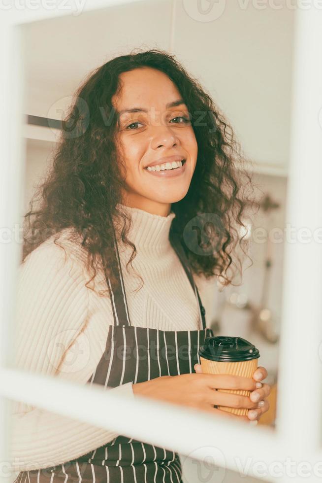 latinsk kvinna dricker kaffe i köket foto