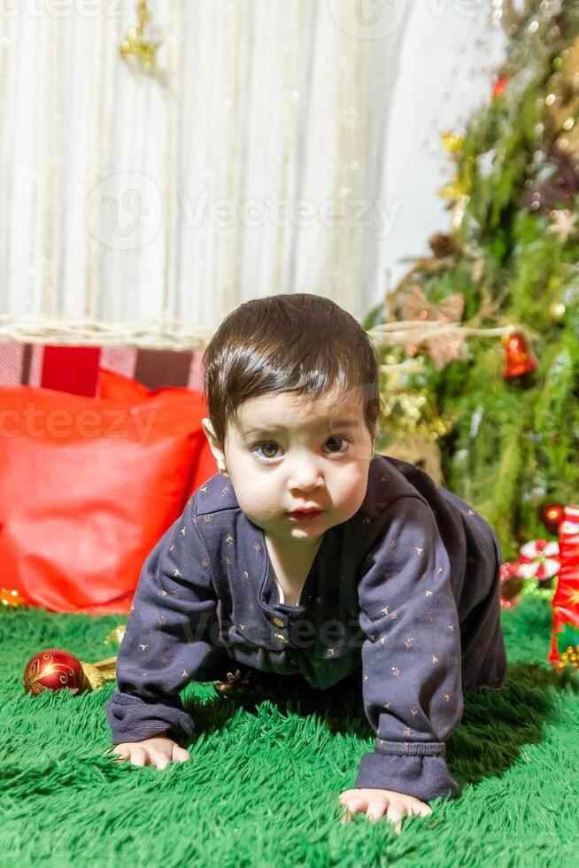 de liten barn spelar med jul dekorationer i studio, liten barn med jul boll foto