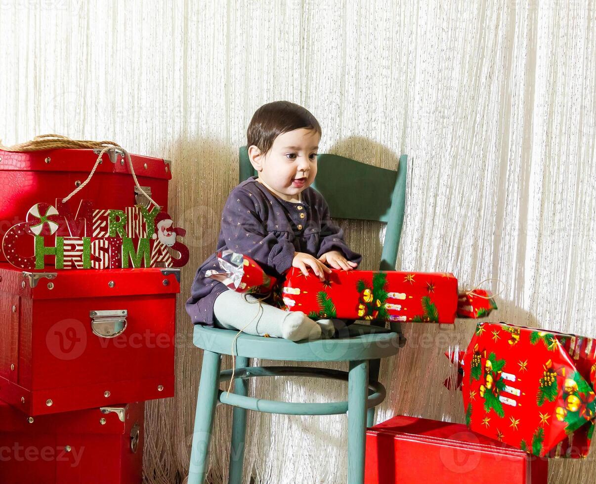 de liten barn spelar med jul dekorationer i studio, liten barn med jul boll foto