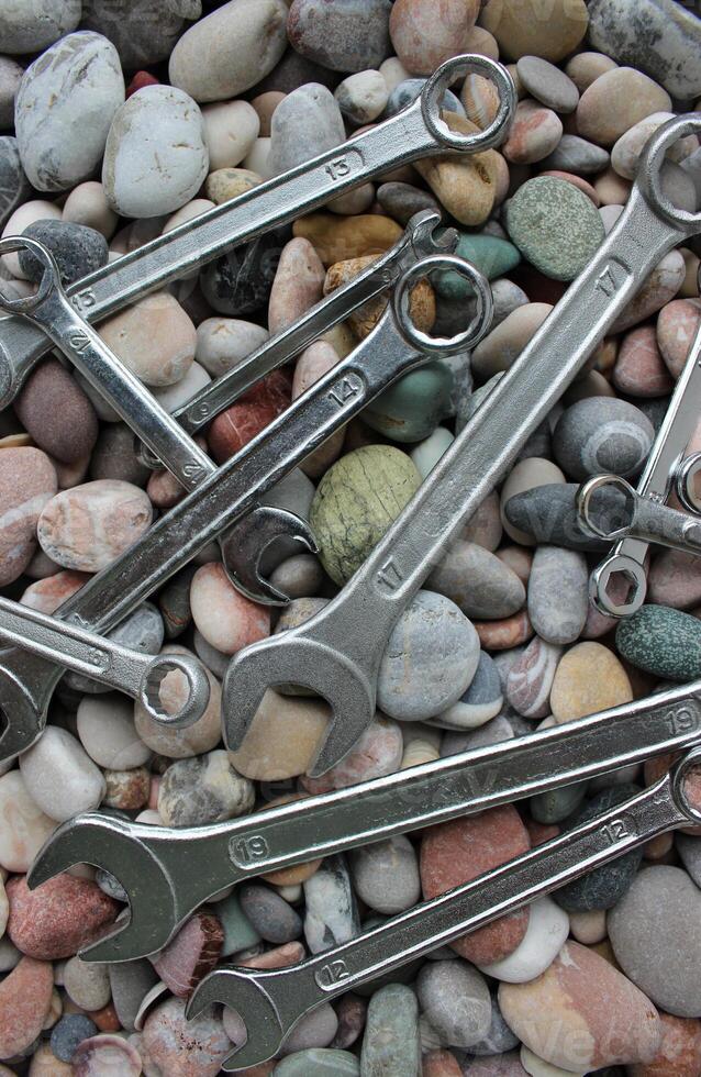 Foto för vertikal bakgrunder av Nycklar och nycklar liggande på en slät stenar