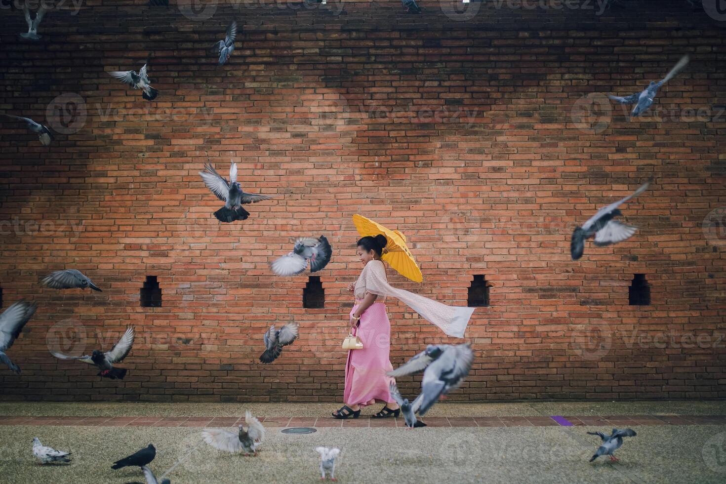 asiatisk flicka och flygande duvor nära tha phae Port på gammal stad i chiang mai thailand foto