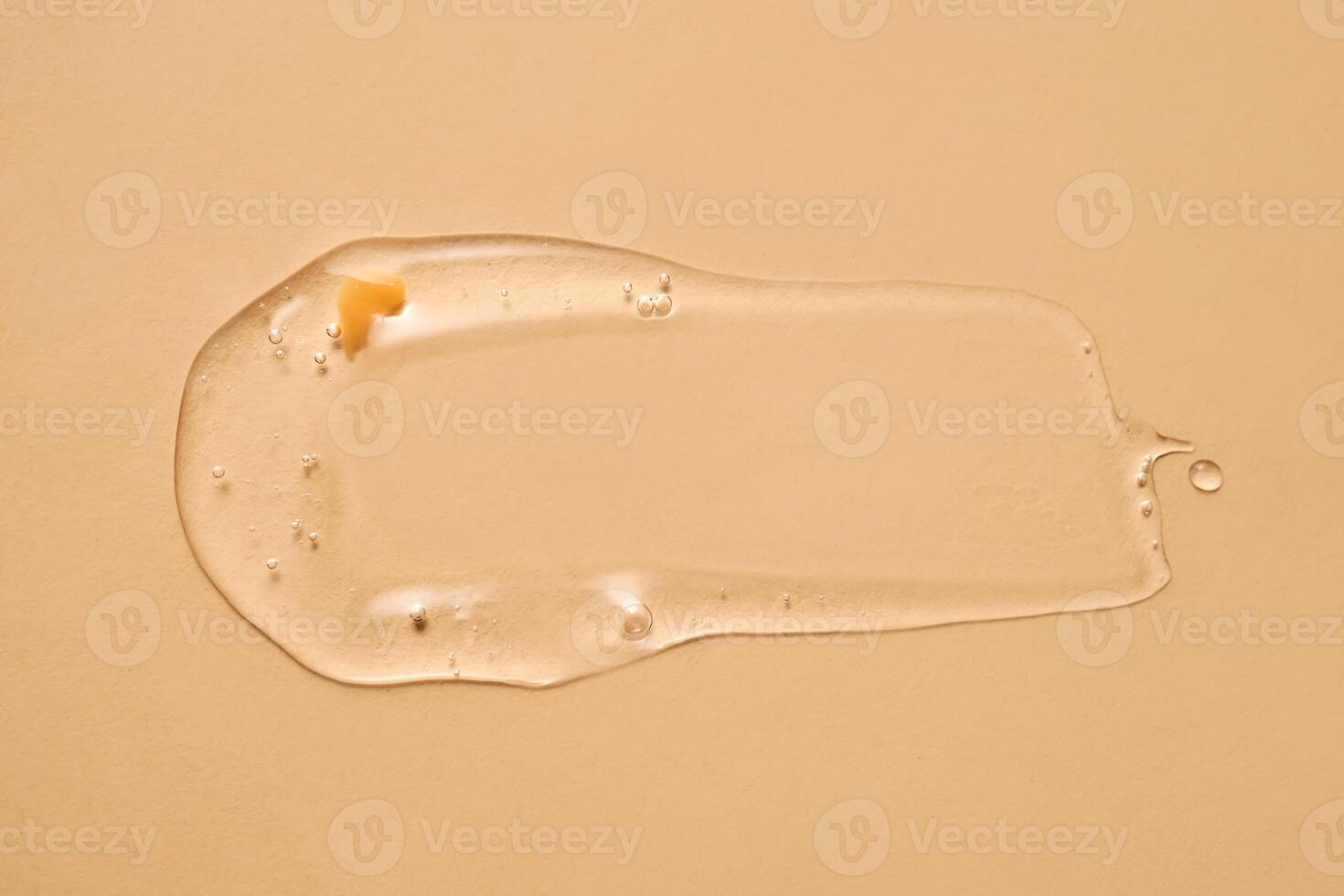 en släppa av transparent kosmetisk gel på en beige bakgrund. foto