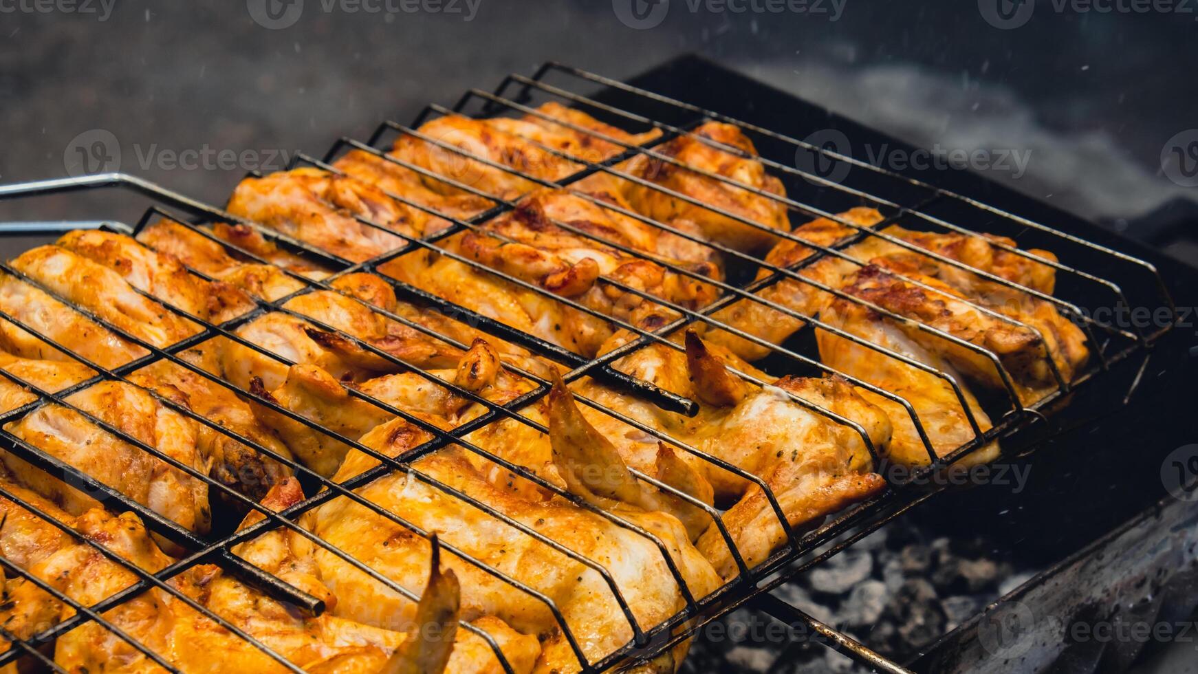 bbq picknick tid rostad kyckling ben och vingar på grill. grillning kött på utomhus- grill rutnät gott grilla kyckling biff med rök lågor saftig kött i de bakgård i sommar foto