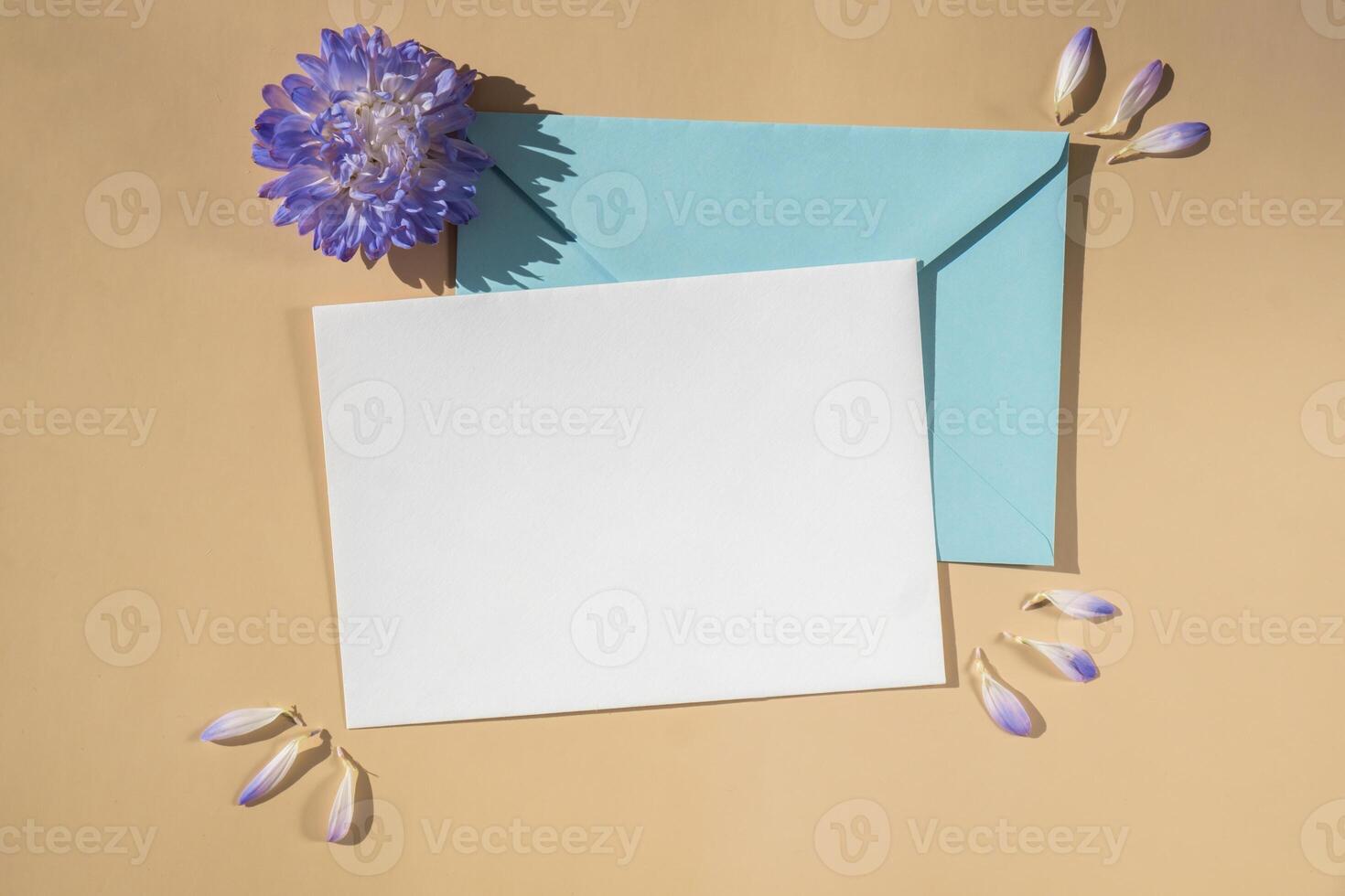 sammansättning med tömma papper notera och kuvert skön vår blå blommor på beige bakgrund. attrapp kort inbjudan hälsning kort vykort kopia Plats mall. blomning färsk naturlig blomma. foto