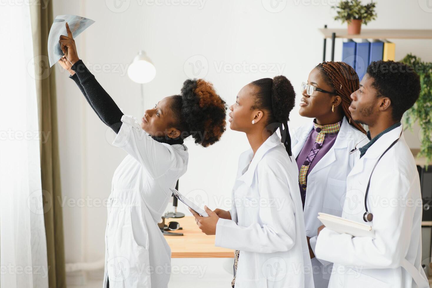 grupp av medicinsk doktorer i kontor med patientens röntgen. foto