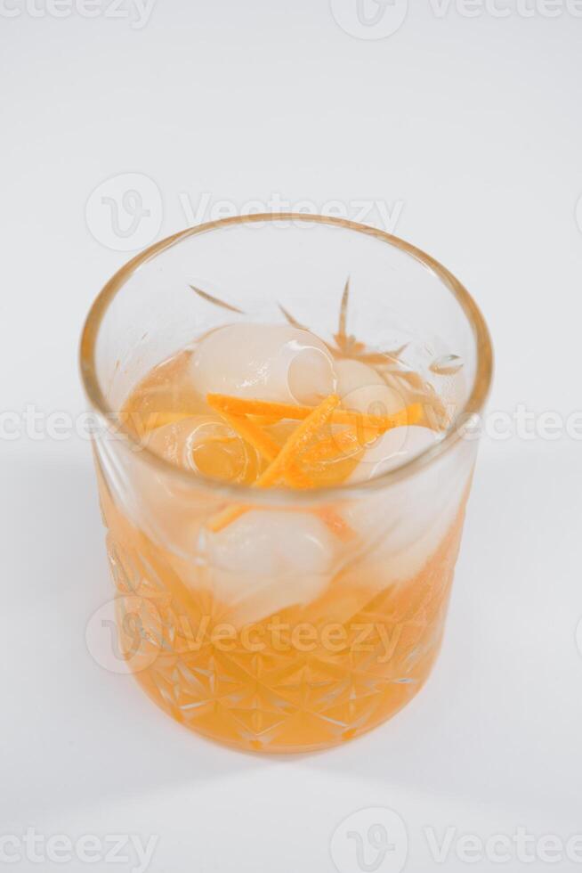 glas av boulevardier cocktail med stor is kub och orange krydda, klassisk cocktail överförfriskad boulevardier med orange och vermouth isolerat på vit bakgrund foto