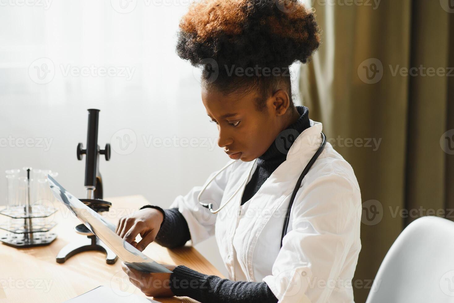 afrikansk läkare ser på patientens röntgen på sjukhus. foto