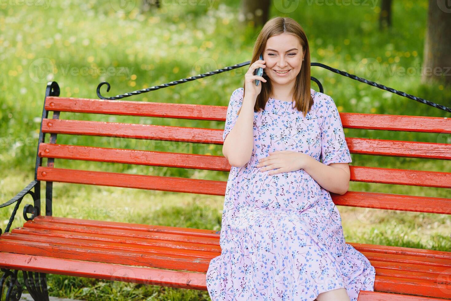 skön gravid kvinna avkopplande i de parkera foto