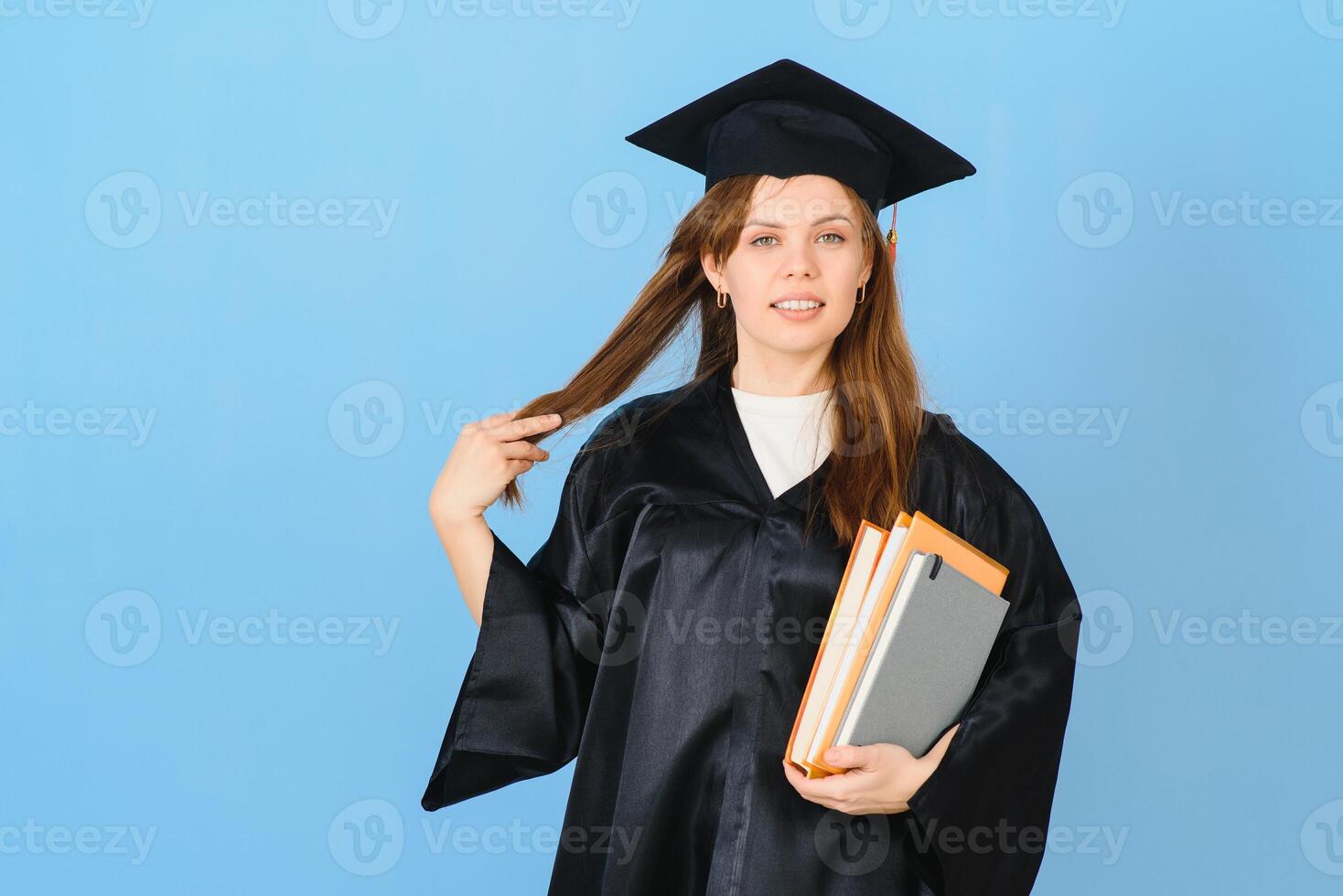 skön kvinna bär gradering keps och ceremoni morgonrock innehav grad ser positiv och Lycklig stående och leende med en självsäker leende. foto