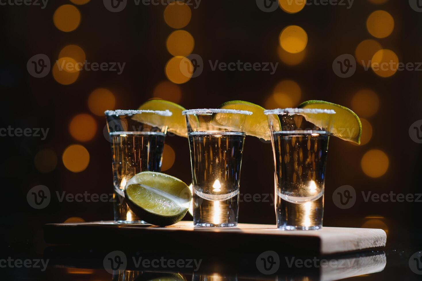 tequila med kalk på en mörk bakgrund foto