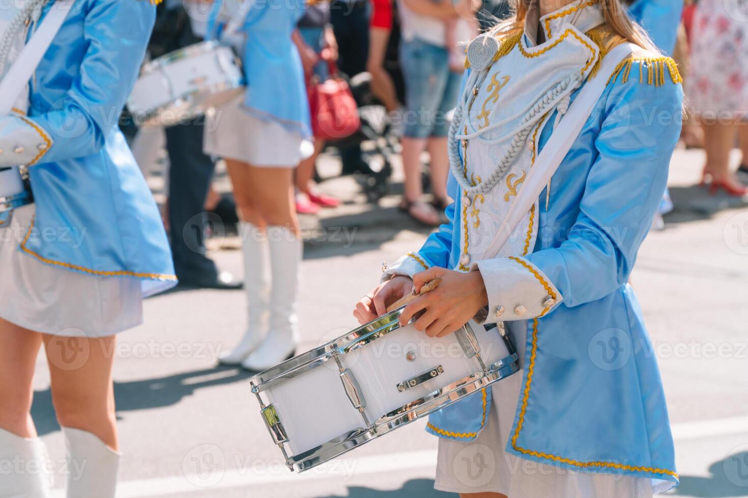 gata prestanda av festlig Mars av trummisar flickor i blå kostymer på stad gata. närbild av kvinna händer trummisar är knackar i de trumma av deras pinnar foto