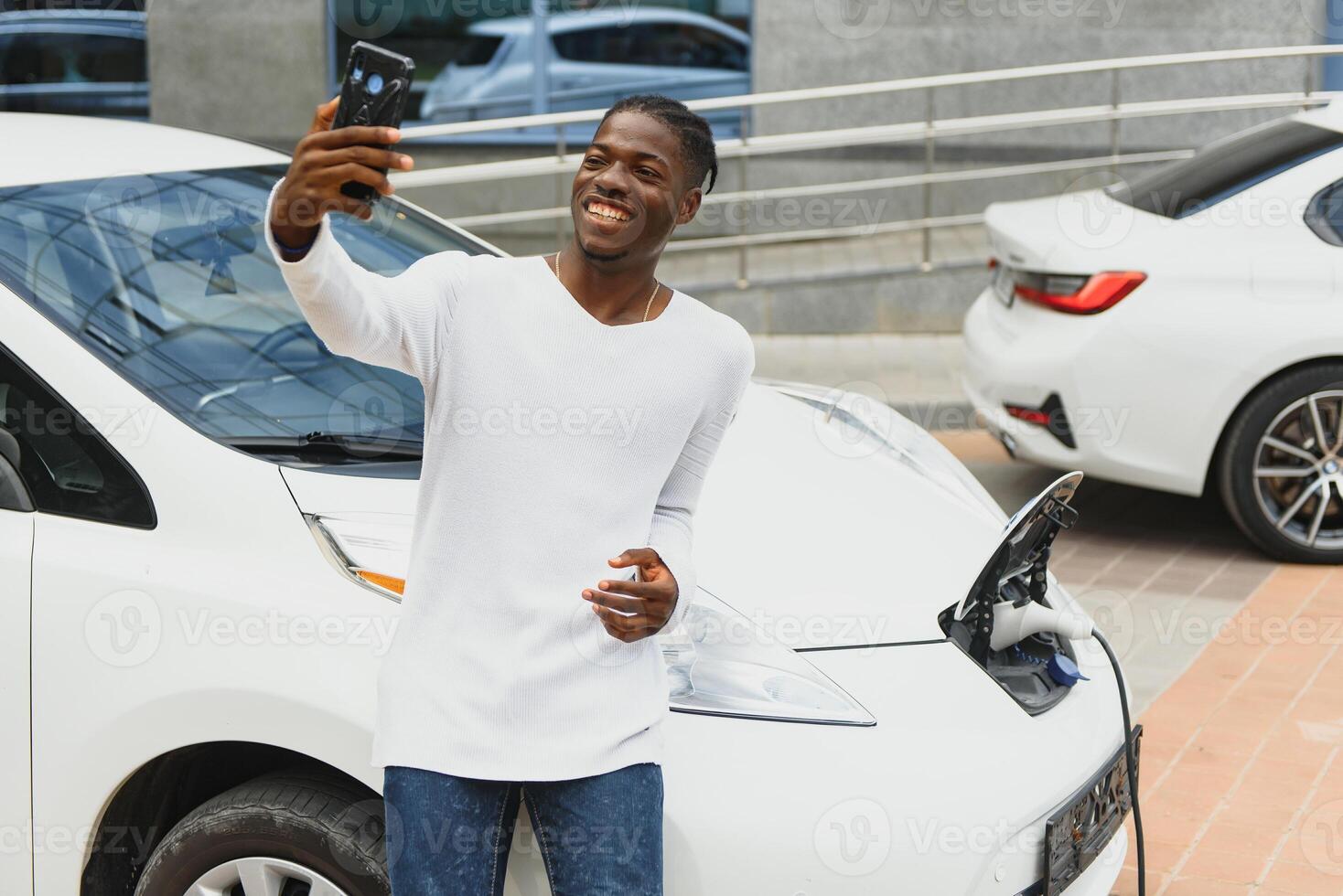 afrikansk amerikan man laddning hans elektrisk bil. foto