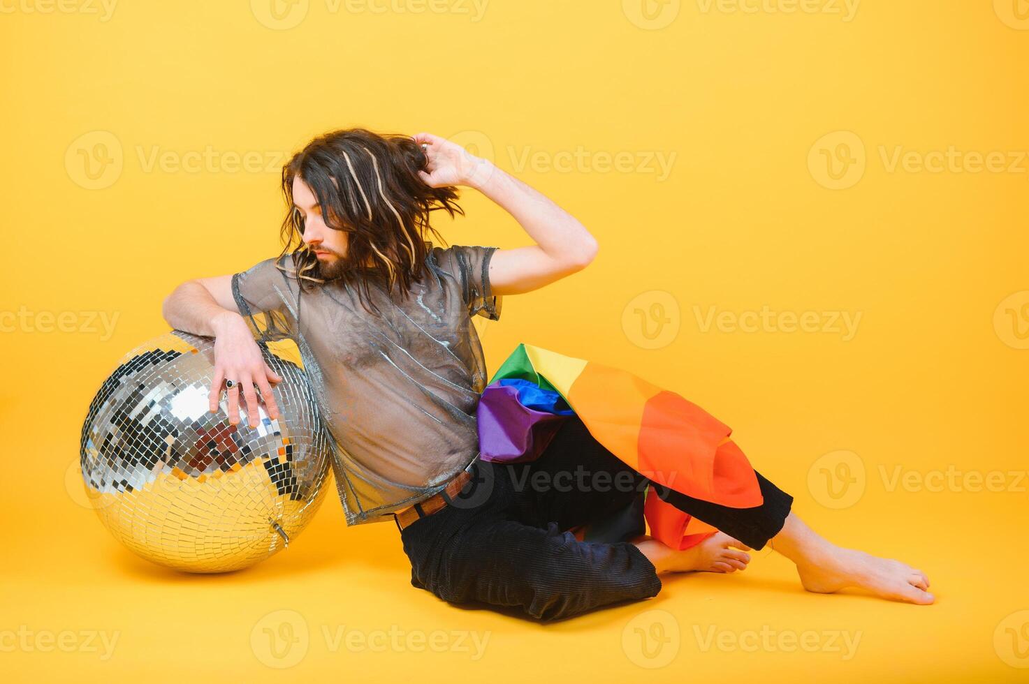 stilig ung man med stolthet rörelse HBTQ regnbåge flagga på axel mot vit bakgrund. man med en Gay stolthet flagga. foto