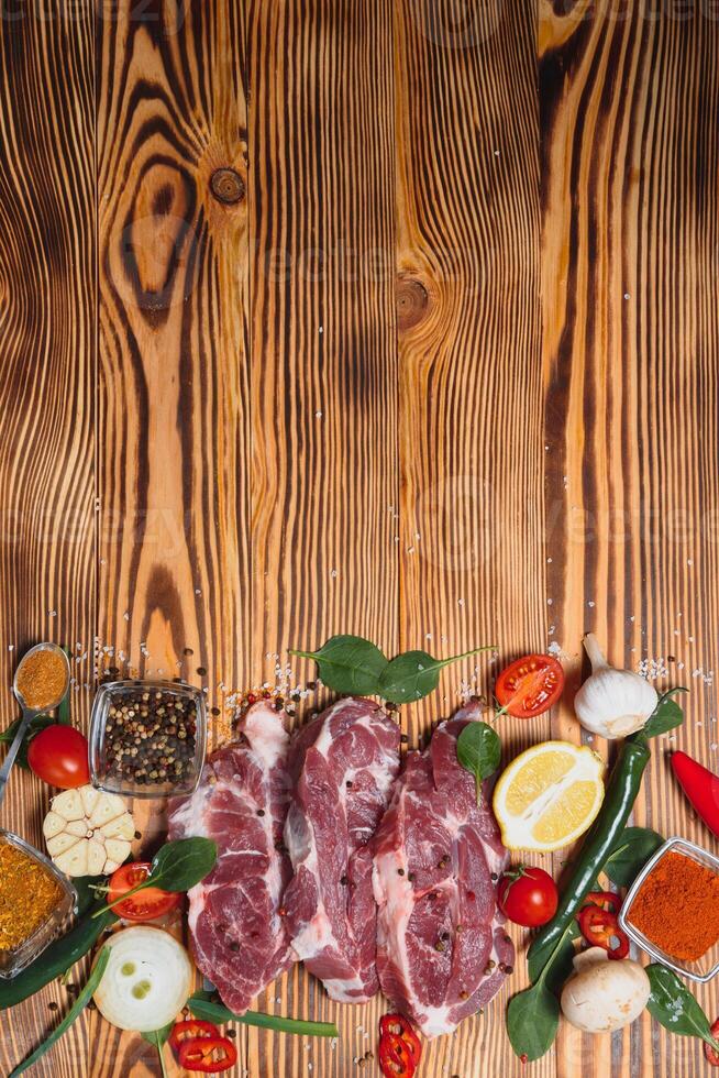 rå fläsk kött på trä- skärande styrelse på kök tabell för matlagning fläsk biff rostad eller grillad med Ingredienser ört och kryddor , färsk fläsk. foto
