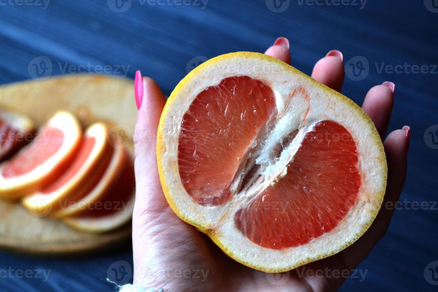 halv av grapefrukt i hand. foto