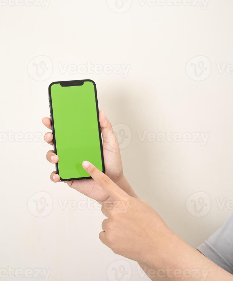 hand är innehav en telefon med grön skärm på en vit isolerat bakgrund foto