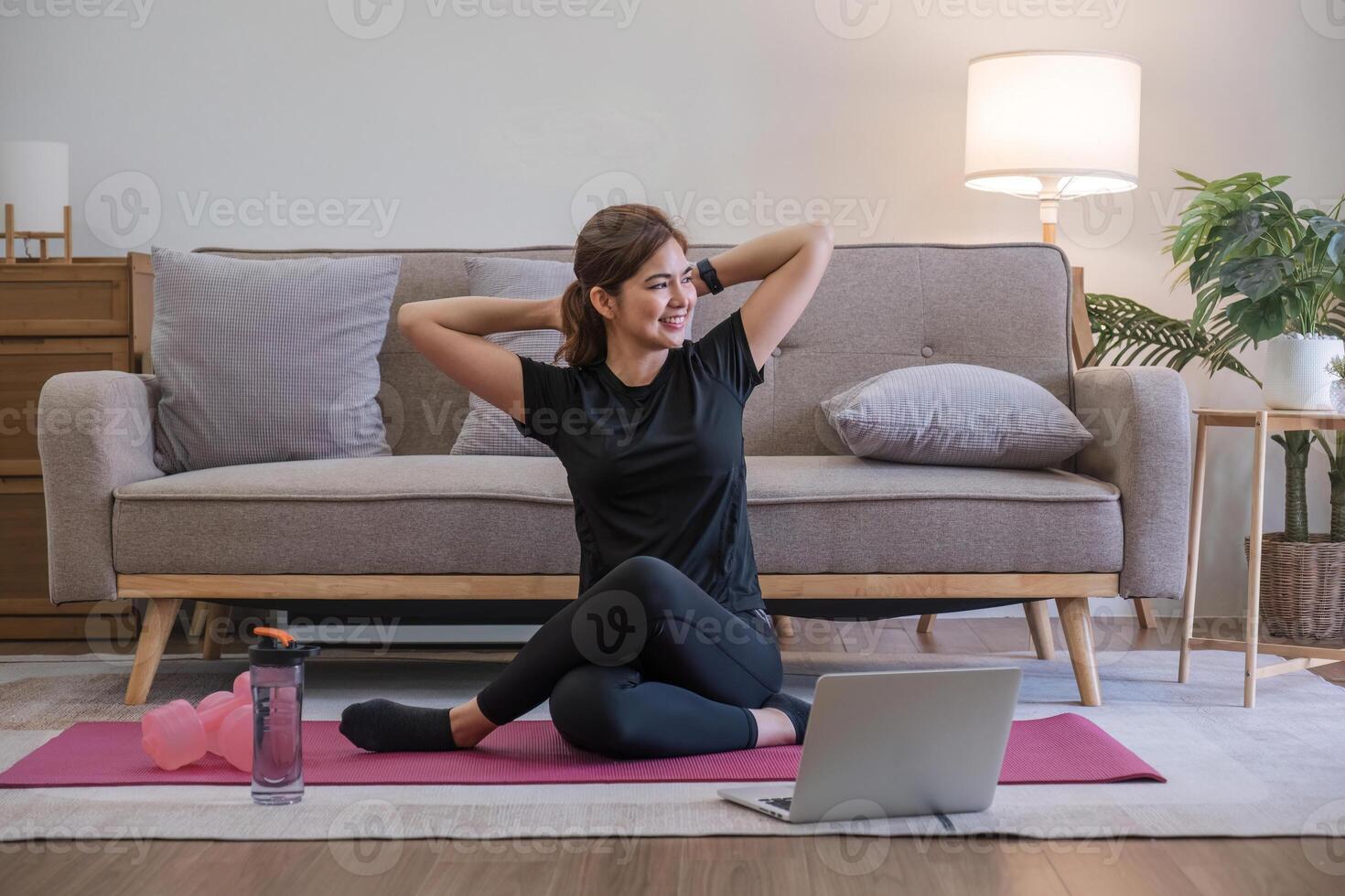 ung asiatisk sportig kondition kvinna tränare do öva video uppkopplad Träning yoga bärbar dator i levande rum på Hem foto