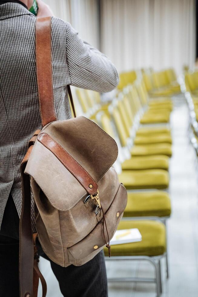 varje väska ryggsäck är bärs på de axel, de man står med hans tillbaka. modern eleganta tillbehör av en affärsman. högskola. foto