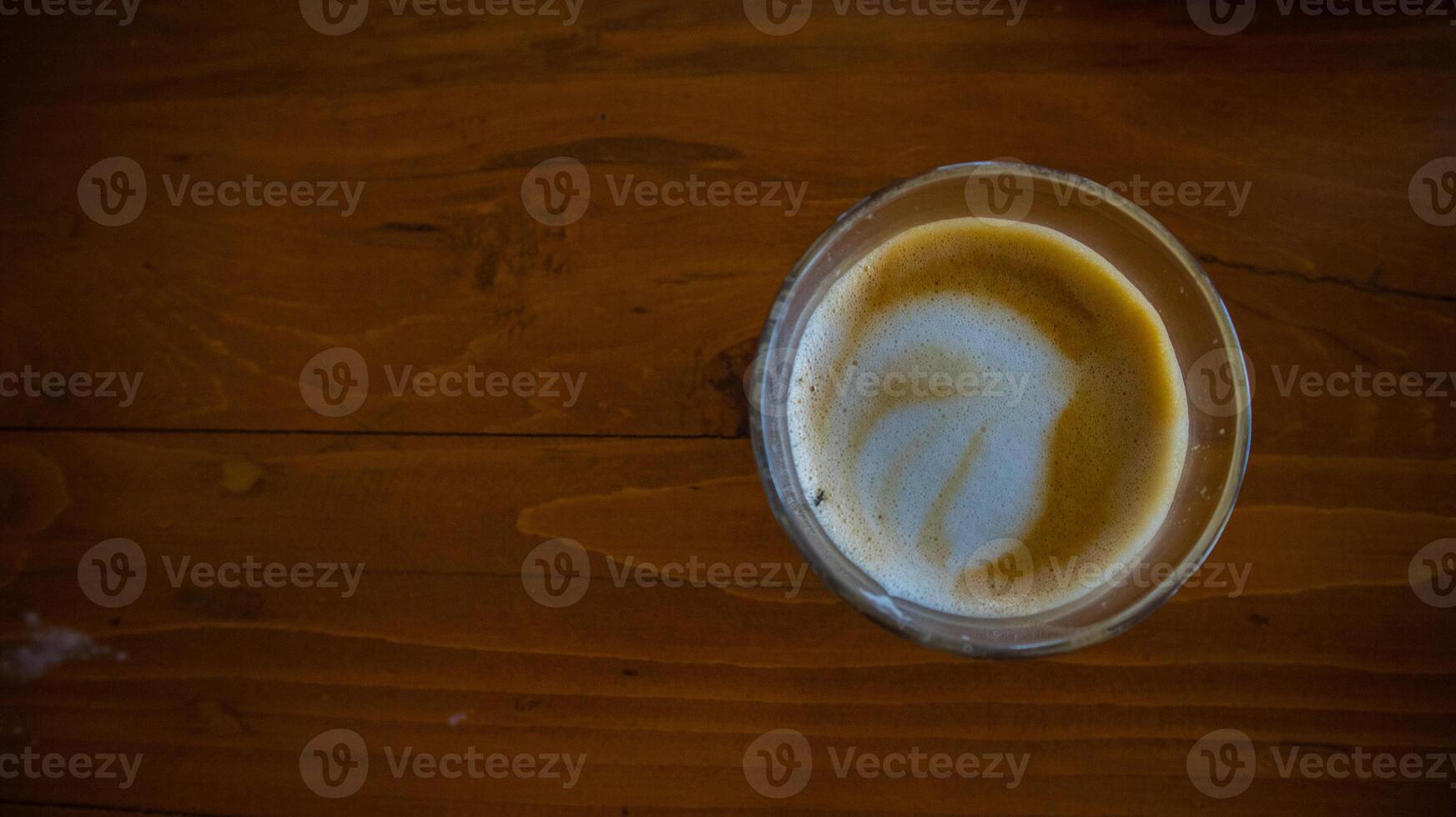 varm latte med latte konst i trä- bakgrund foto