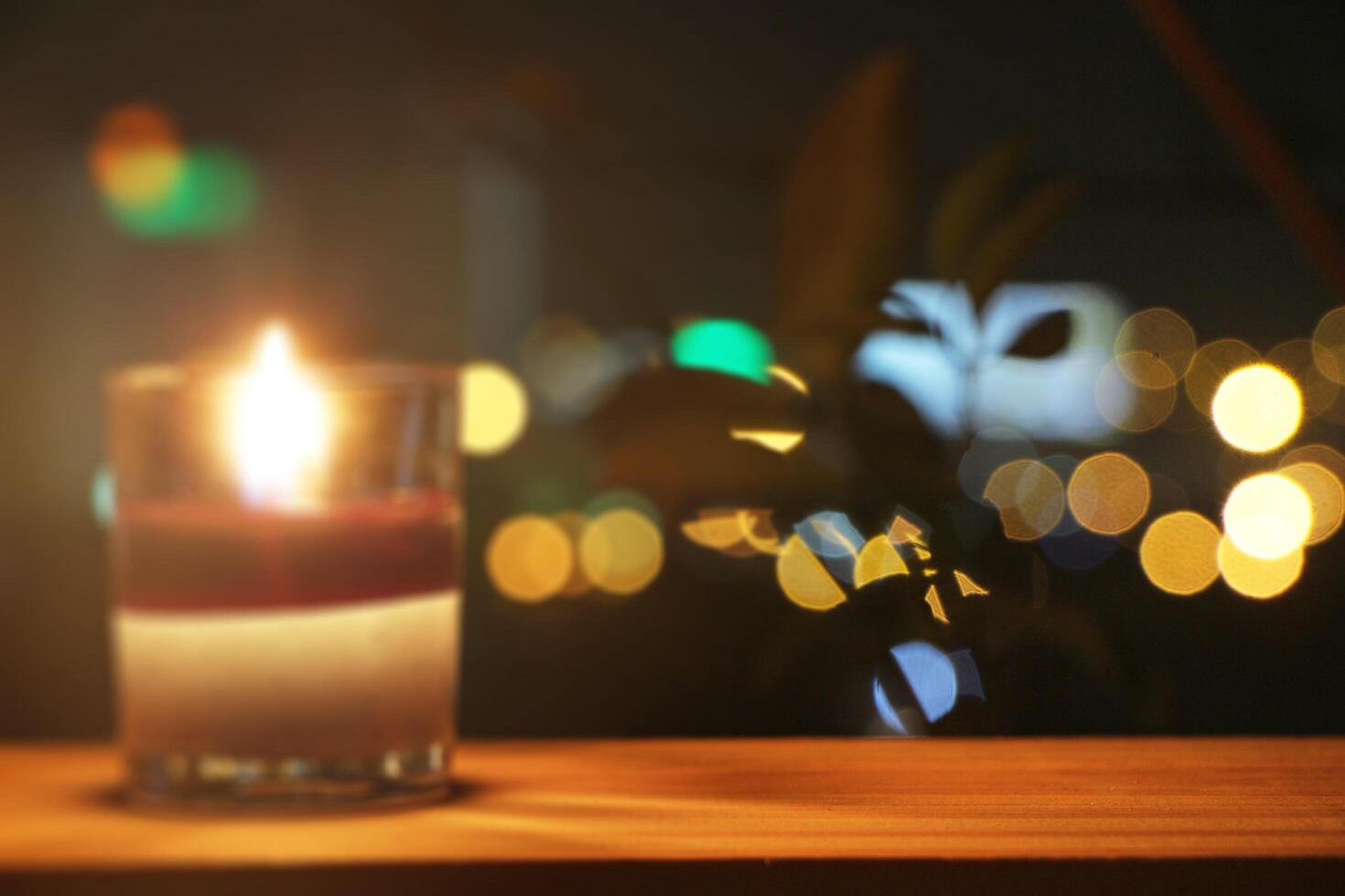 suddig av ljus i en glas på en trä- tabell på de balkong med bokeh bakgrund. foto