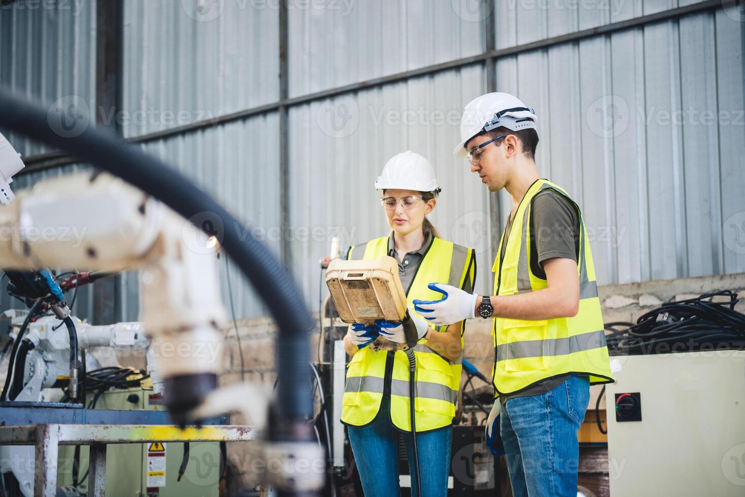 ingenjörer team mekaniker använder sig av dator kontrollant robot ärm för svetsning stål i stål fabrik verkstad. industri robot programmering programvara för automatiserad tillverkning teknologi foto