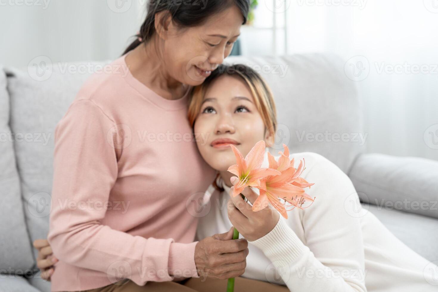 mor dag, söt asiatisk tonåring flicka kramas mogna mitten ålder mamma. kärlek, kyss, vård, Lycklig leende njut av familj tid. fira särskild tillfälle, Lycklig födelsedag, glad jul. särskild dag foto