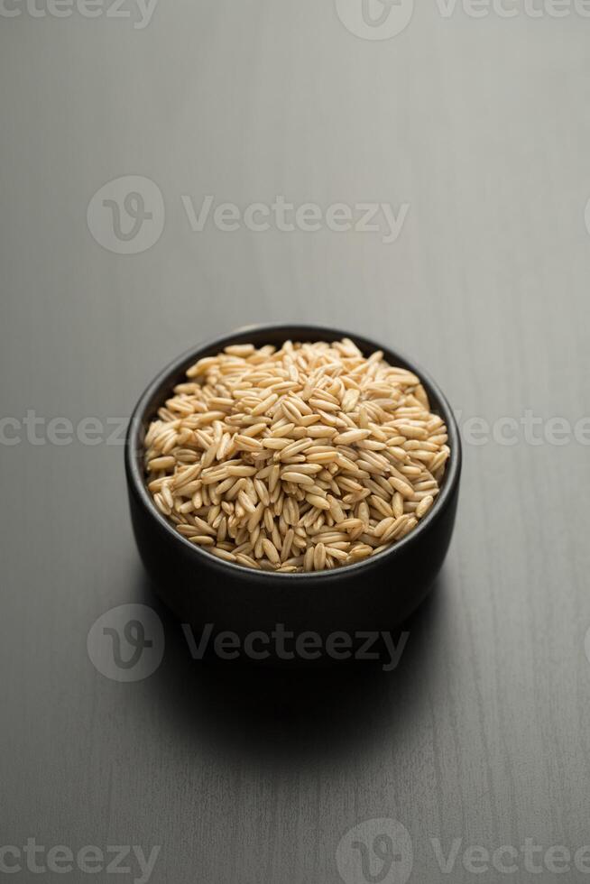 havre ris på en svart skål foto